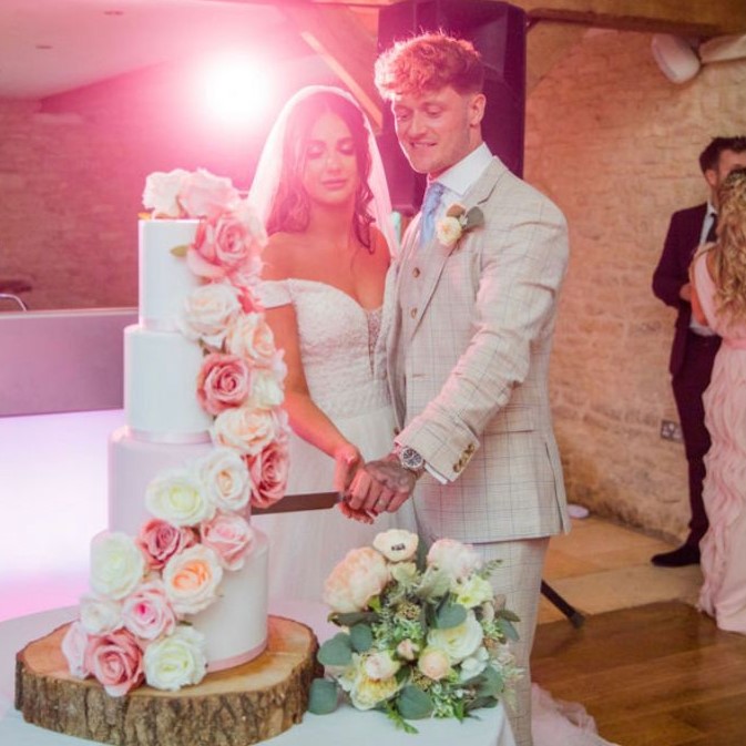 Couple cutting fake wedding cake